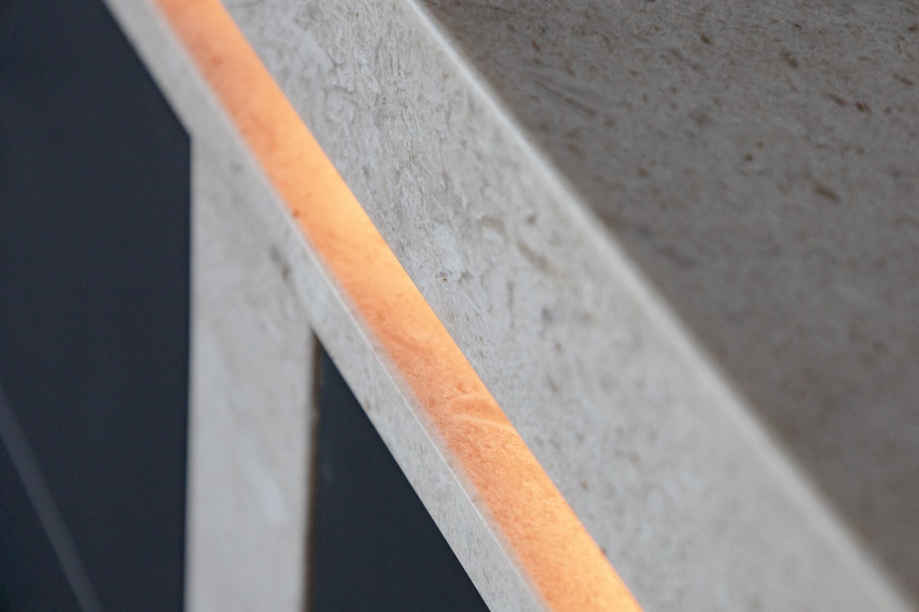 Close detail of warm concealed linear LED inside an architectural material