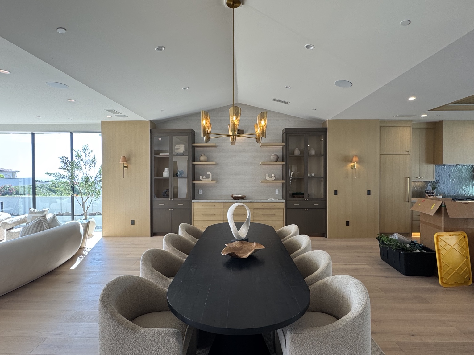 Dining room with sculptural chandelier, wall sconces and planned recessed lighting