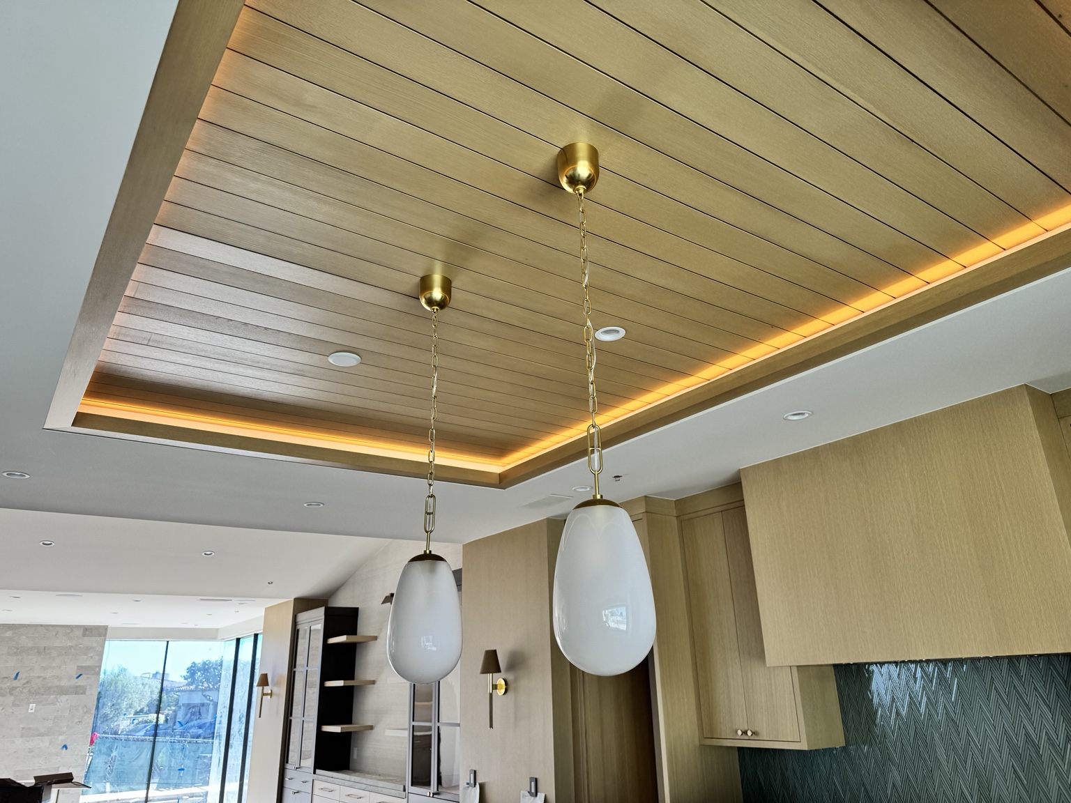 Warm linear cove lighting around a wood kitchen ceiling